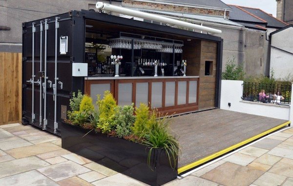 Shipping container converted into an outdoor bar with timber decking